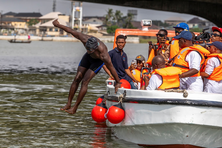 Akinrodoye Samuel jumps into the water to start his 11.8km 'Swim Against Suicide And Depression' in Lagos, Nigeria, on March 30 2024.