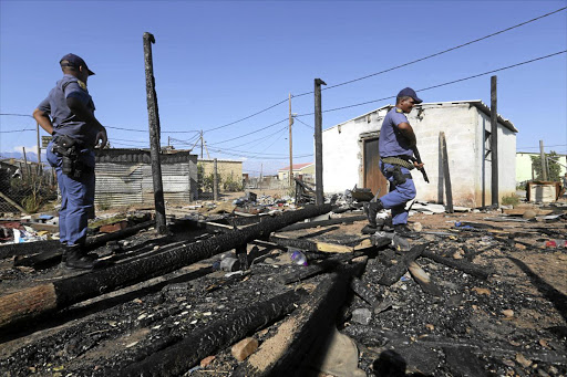 Police patrol Avian Park, where nine houses were destroyed.