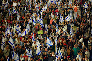 People hold banners and Israeli flags in Tel Aviv on April 13 2024 as they attend a protest against Israeli Prime Minister Benjamin Netanyahu's government and to call for the release of hostages kidnapped in the deadly October 7 attack on Israel by Hamas from Gaza. File photo.
