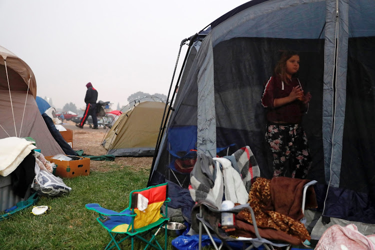 Serenity Bravo-Robertson, 10, of Paradise, stands in her family's tent at a makeshift evacuation center for people displaced by the Camp Fire in Chico, California, U.S., November 15, 2018.