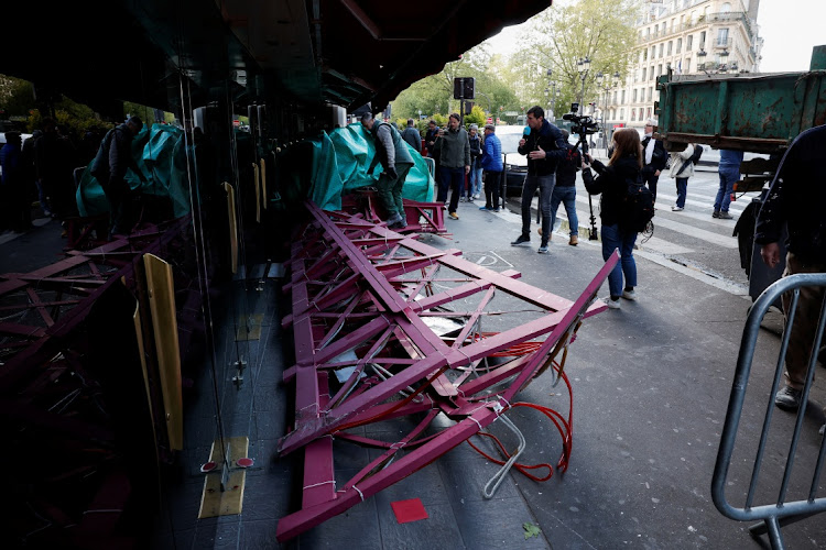 Sails of the landmark red windmill atop the Moulin Rouge, Paris's most famous cabaret club, are seen on the ground after they fell off during the night in Paris, France, on April 25 2024.