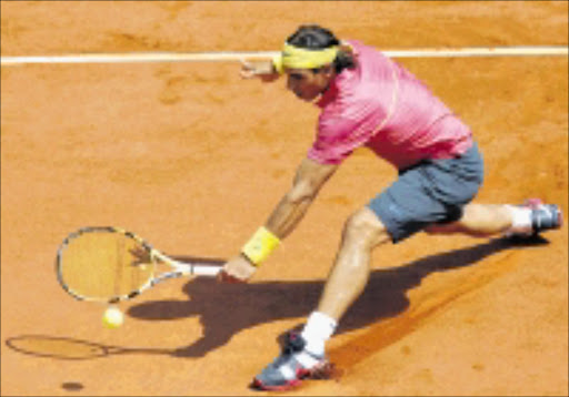 OUTSTRETCHED: Defending champion Spain's Rafael Nadal returns the ball to Brazil's Marcos Daniel during their first round match of the French Open tennis tournament at the Roland Garros stadium in Paris yesterday. 25/05/09. Pic. Christopher Ena. © AP.