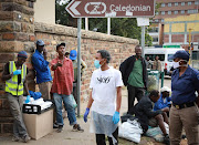 Homeless men stand outside the Caledonian stadium in Pretoria where hundreds of homeless people were moved to in an effort to curb the spread of Covid-19 on March 31 2020.