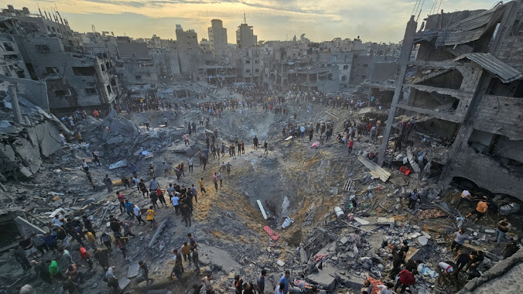 Palestinians search for casualties at the site of Israeli strikes on houses in Jabalia refugee camp in the northern Gaza Strip on Tuesday