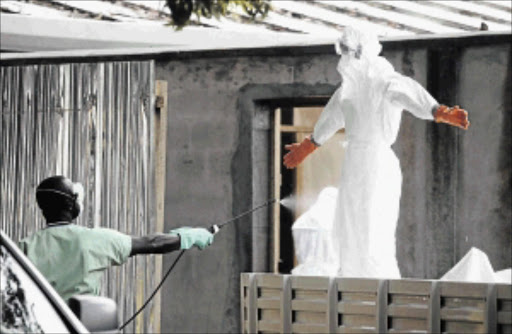 DISEASE PROTECTION: Liberian nurses in protective gear fight ebola photo: AHMED/epa