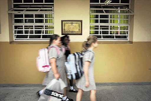 School girls walk past a classroom. File photo.