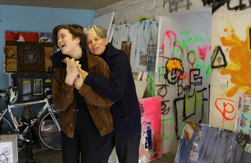 Josie Borain and her daughter Willow in Borain's bike-and-collage-filled Hout Bay garage studio.