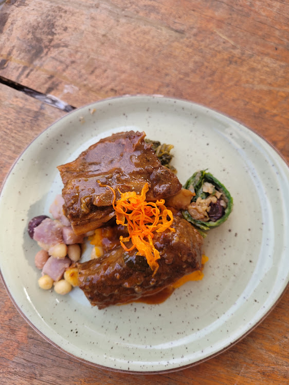 Slow-cooked flat ribs and amadumbe on a bed of roasted lefodi mash, served with steamed cabbage and mochaina and topped with crispy carrots and sprinkles of moringa powder by chef Themba Chauke.