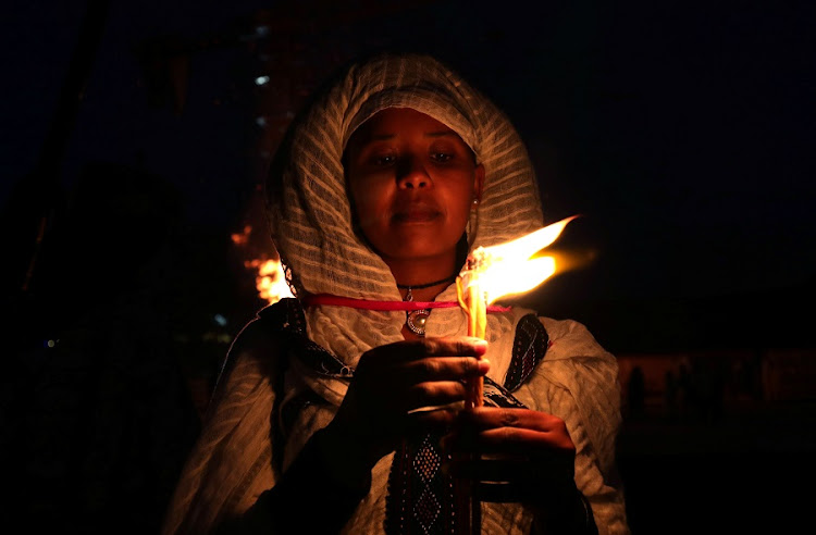 An Ethiopian Orthodox faithful holds a burning candle during the Meskel Festival to commemorate the discovery of the true cross on which Jesus Christ was crucified on, in Addis Ababa, Ethiopia, September 26, 2020.