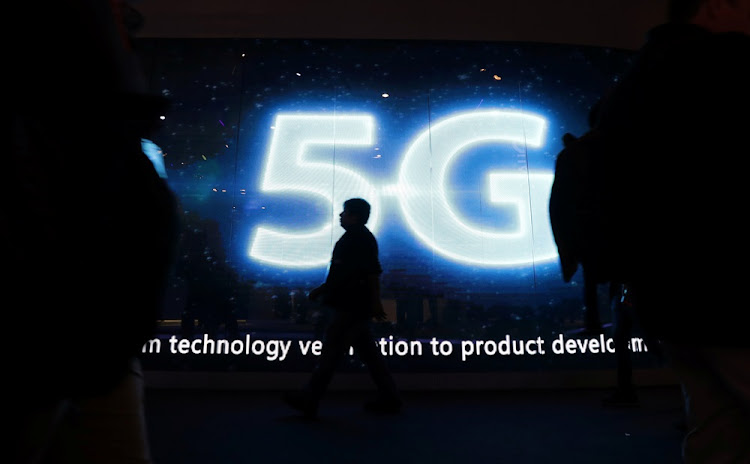 A visitor walks past a 5G sign during Mobile World Congress in Barcelona, Spain. Picture: REUTERS