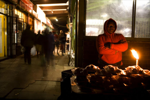 09 Jun 2006 --- A woman sells meat in a pedestrian arcade near the Baragwanath taxi rank in Soweto --- Image by © Gideon Mendel/Corbis