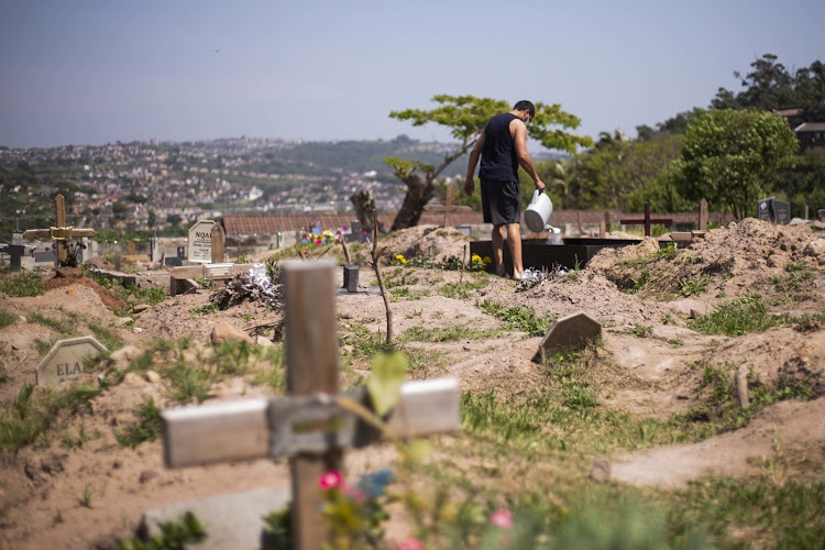 Antonio O’Reilly waters plants on his mother-in-law’s grave at Durban's Queensburgh Cemetery, which has run out of space.