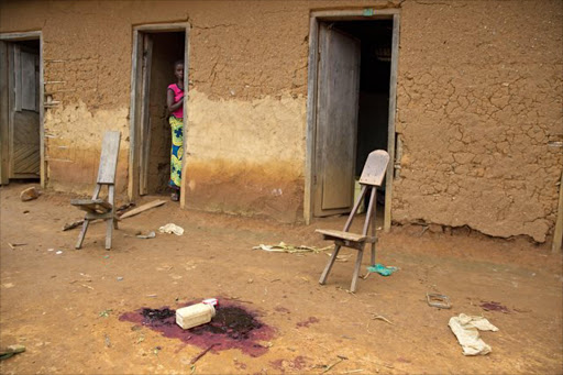 December 2, 2014. A woman packs her belongings after an attack in Mapiki village in Eringeti. Three people died and three were left fighting for their lives. Beni area, North Kivu Province, DRC.