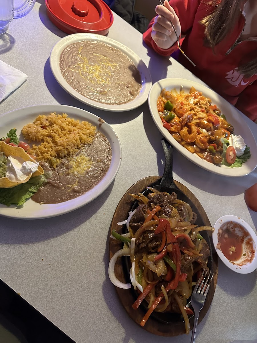 Steak fajitas (front) and arroz con camarones with side of beans (across table). Fajitas were amazing! Arroz con camarones was good but needed more rice.