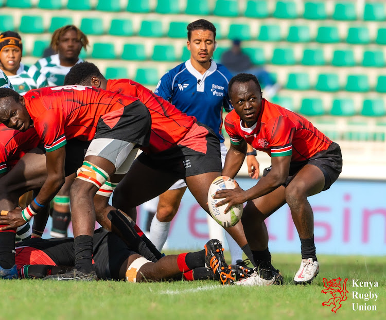 Kenya Under-20 scrum-half Zephenes Obwanga looks to pass the ball to teammate during the Barthes cup final against Zimbabwe on Sunday