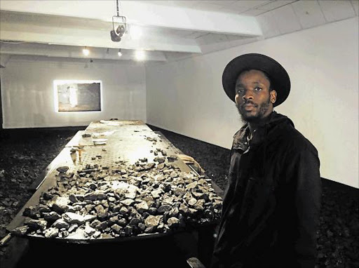 Thought-provoking: Young Artist for Visual Art Mohau Modisakeng at his festival exhibition, Lefa la Ntate, showing the black male in relation to the economy and society, past, present and future Picture: GILLIAN McAINSH