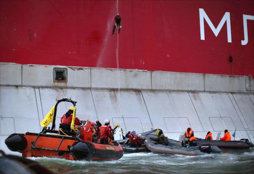 A handout photo taken by Greenpeace shows Greenpeace activists boarding Gazprom’s ‘Prirazlomnaya’ Arctic oil platform somewhere off Russia north-eastern coast in the Pechora Sea.