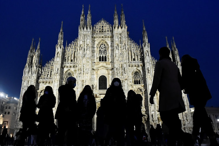 People walk in front the Duomo Cathedral. Italians will only be allowed to leave their homes for work, health or emergency reasons during the Easter holidays.
