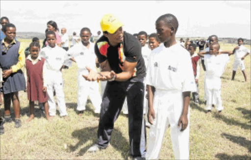 IMPARTING SKILLS: Former Proteas bowler Makhaya Ntini gives young Mfusi Ludude a few handy tips on the game at a coaching clinic for schools at Cwili village in Kei Mouth yesterday. Photo: MLONDOLOZI MBOLO