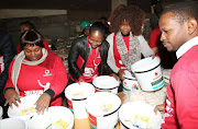 Vodacom employees and other volunteers pack food parcels ahead of Mandela Day 2017.