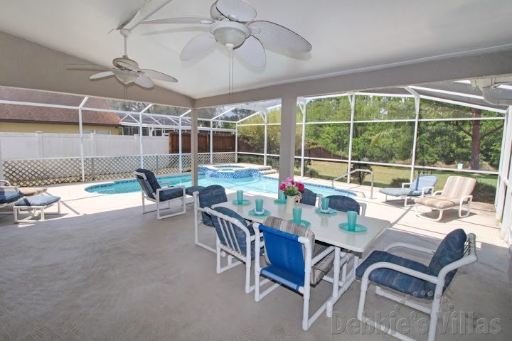 Covered dining area by the pool of this Westridge villa in Davenport