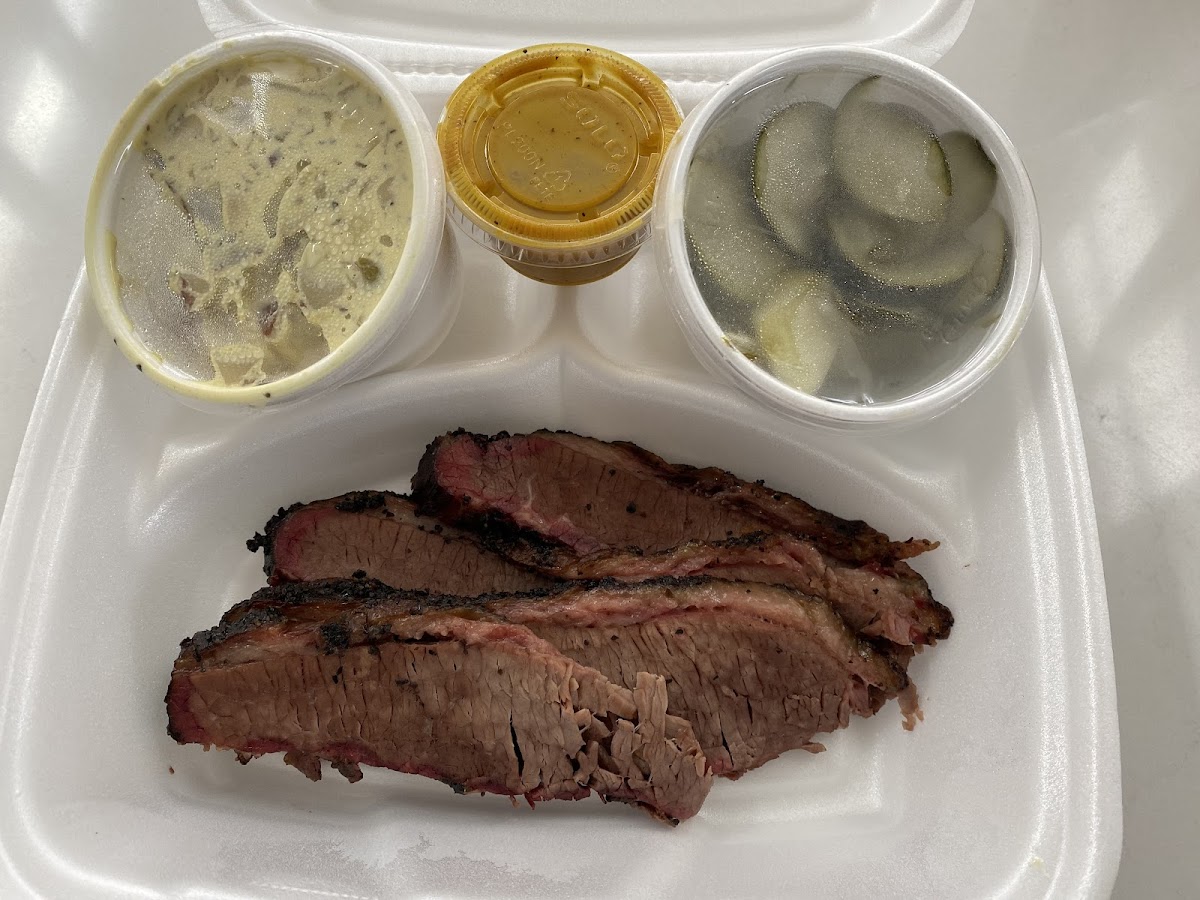 Brisket with potato salad, pickles, and NC style mustard BBQ sauce