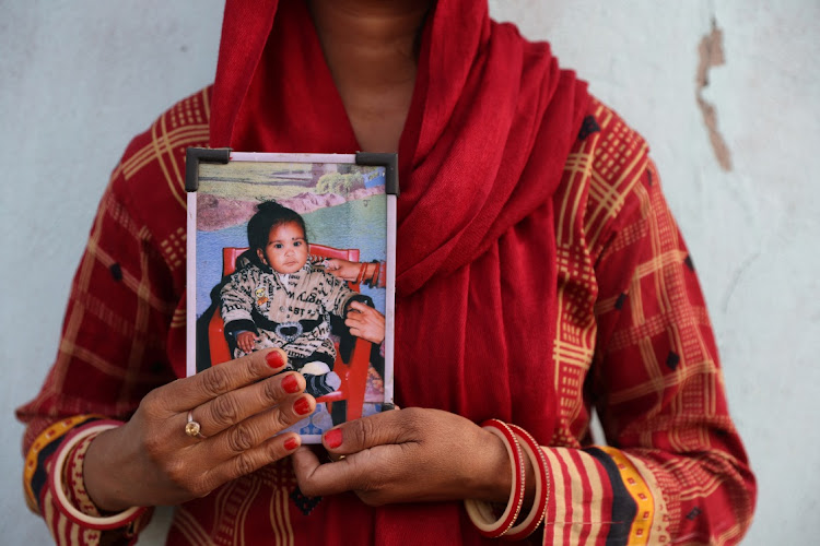 Poli Devi holds a picture of 11-month-old Janvi, who was among the children who died after consuming cough syrup, in Ramnagar, Jammu, India, March 28 2023. Picture: ANUSHREE FADNAVIS/REUTERS