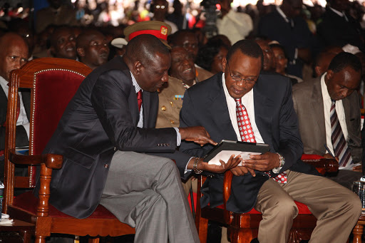 Uhuru Kenyatta and Deputy President William Ruto use an iPad during the official launch of the Inua Jamii Cash Programmes at Ihura stadium, Murang'a County