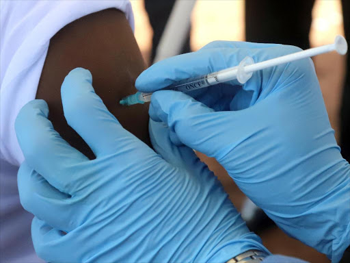 A World Health Organisation (WHO) worker administers a vaccination during the launch of a campaign aimed at beating an outbreak of Ebola in the port city of Mbandaka, Democratic Republic of Congo May 21, 2018. /REUTERS