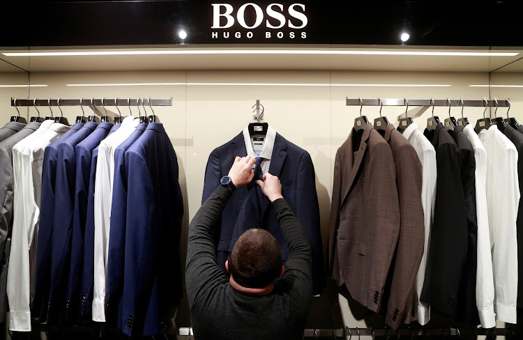 An employee displays suits at the Hugo Boss section of the Central Universal Department Store (TSUM Kyiv) in Kyiv, Ukraine. Picture: REUTERS/VALENTYN OGIRENKO/FILE