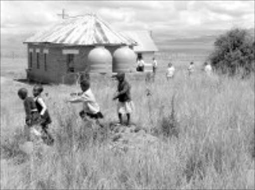 SCHOOL BREAK: Pupils having fun running over gravesites on thier school 'playground'. Pic. Kamva Mokoena. 21/01/2007. © Sowetan.