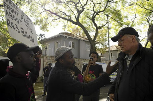 A Black First Land First member confronts former Business Day and Financial Mail editor Peter Bruce outside his Johannesburg home over opinion pieces he wrote about the Gupta family Image: LEFEDI RADEBE