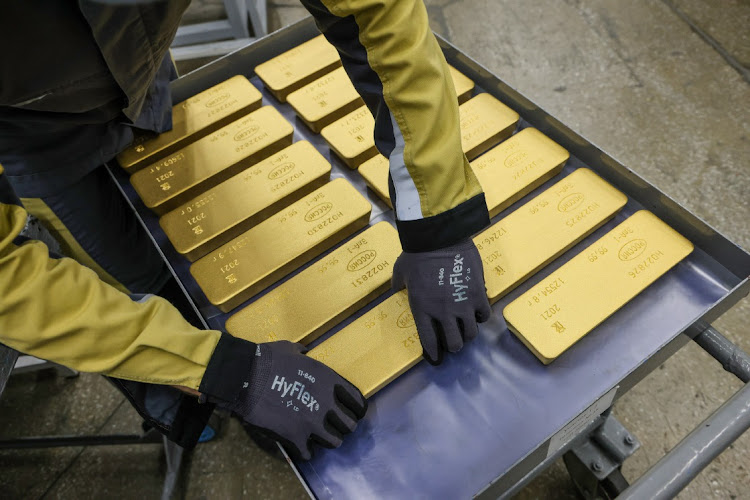 A worker loads 12,5kg gold ingots onto a trolley ready for distribution at the JSC Krastsvetmet non-ferrous metals plant in Krasnoyarsk, Russia. Picture: BLOOMBERG/ANDREY RUDAKOV