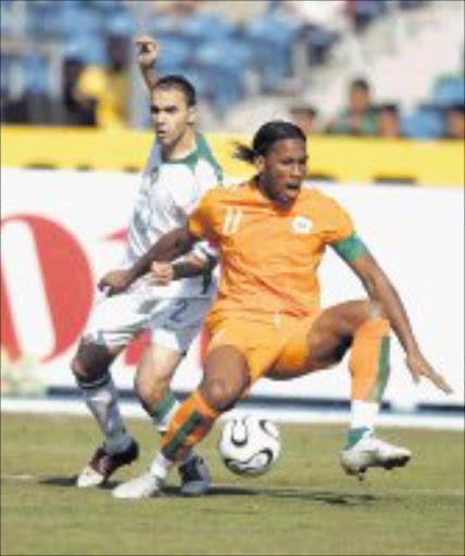 QUICK ON THEIR FEET: Morocco's Oualid Regragui and Ivory Coast's Didier Drogba battle for the ball. © UNKNOWN.