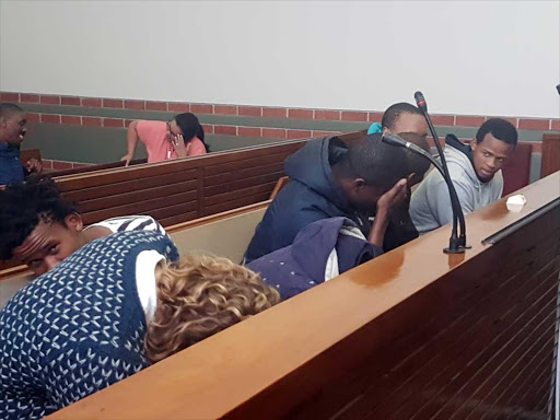 IN THE SPOTLIGHT: Five Rhodes University students arrested over the weekend hide from the camera during their brief appearance in court yesterday Picture: DAVID MACGREGOR