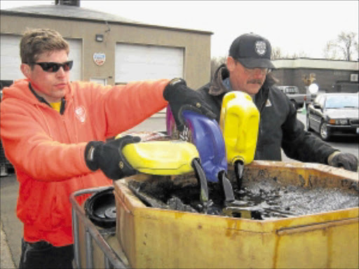 ENCOURAGING: Workers collecting used oil for recycling.