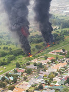 Thick smoke pours over houses in Alberton, Ekurhuleni, on Tuesday after a fuel pipeline caught fire.