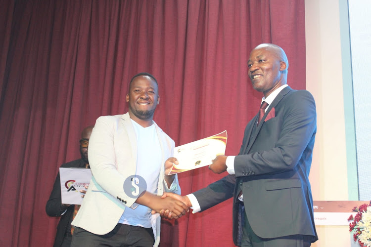 Best over 30 video editor first runners up receives a certificate from Kenya Film Commission CEO Timothy Owase during the Inaugural Content Creator Awards ceremony at the National Museums, Nairobi on April 4, 2024