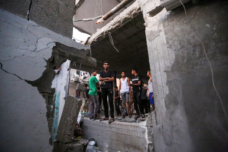 People search through buildings that were destroyed during Israeli air raids in the southern Gaza Strip in Khan Yunis. Picture: AHMAD HASABALLAH