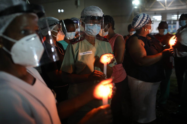 Health care workers join the commemorative ceremony observed across the country and light candles for Covid-19 victims at Charlotte Maxeke Hospital in Johannesburg.