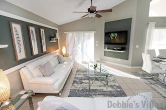 Wall-mounted flatscreen TV and doors to the pool deck in the lounge