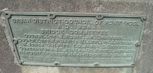 The plaque on the bridge Link across the Afon Lwyd records the bridge's opening in 1924, and the names of the bridge committee. The bottom two lines record that the pilaster (on which the plaque...