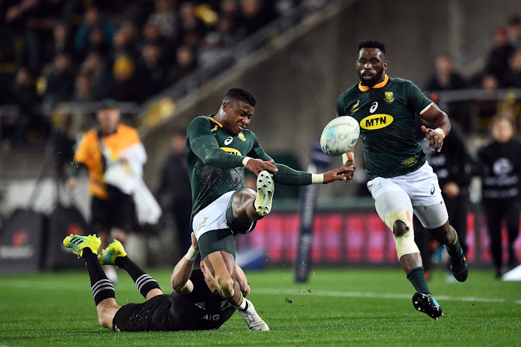 South Africa's Aphiwe Dyantyi kicks the ball away to avoid the tackle from All Blacks' Beauden Barrett during the Investec Rugby Championship between All Blacks vs the Springboks at Westpac Stadium in Wellington on Saturday September 15 2018.