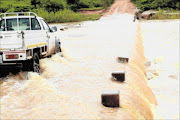 SUBMERGED: A bakkie crosses the overflowing Luvuvhu River at Hasani in Giyani seems particularly risky for vehicles crossing it. PHOTO: ELIJAR MUSHIANA