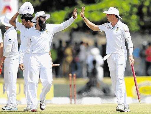 HIGH FIVES: Proteas captain Hashim Amla, centre, celebrates with team-mate Dale Steyn after the team's victory in the opening Test match against Sri Lanka at the Galle International Cricket Stadium yesterday. South Africa won the Test by 153 runs on the fifth and final day