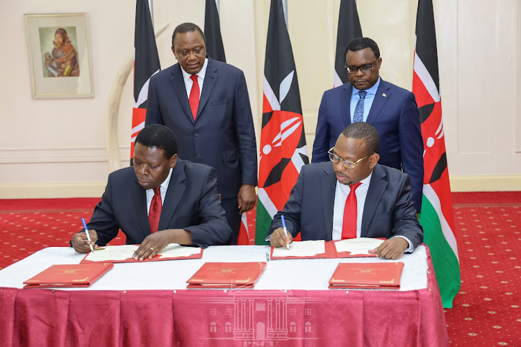 President Uhuru Kenyatta and Senate Speaker Kenneth Lusaka look on as Nairobi Governor Mike Sonko and Devolution CS Eugene Wamalwa sign the agreement at State House, Nairobi on February 25, 2020.