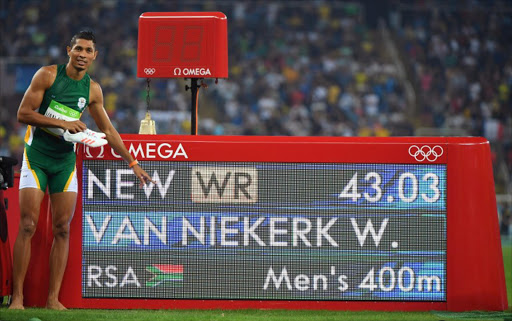 South Africa's Wayde van Niekerk poses by the results board after he broke the world record in the Men's 400m Final during the athletics event at the Rio 2016 Olympic Games at the Olympic Stadium in Rio de Janeiro on August 14, 2016.