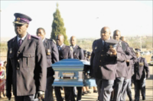 SOLEMN: Inspector Andrew Rapeta's, inset, funeral yesterday. Pic: Peggy Nkomo. 20/09/2009. © Sowetan.