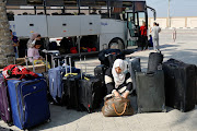 A Palestinian holding a foreign passport looks through her bag as she waits for permission to leave Gaza, amid the ongoing conflict between Israel and Palestinian Islamist group Hamas, at the Rafah border crossing with Egypt, in Rafah in the southern Gaza Strip, November 3, 2023.
