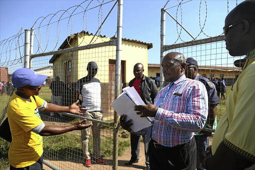 HEARTFELT: Deputy education circuit manager CM Madikizela looks at a memorandum from Siwayaya ANC branch chair Vusumuzi Mzobe and community members about a school principal who allegedly impregnated two pupils. They demanded action be taken within seven days.